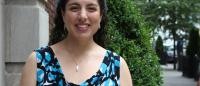 Photo of faculty member Adriana Arcia, smiling outside in front of the former Columbia Nursing building.